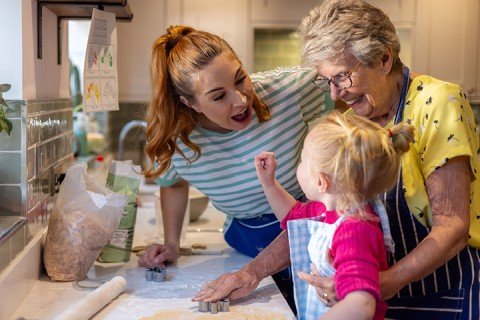 Mother and Grandmother bake in the kitchen with toddler