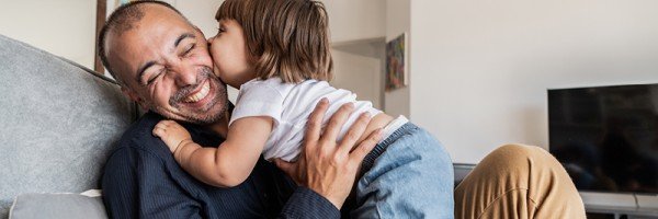 Dad cuddles with young child