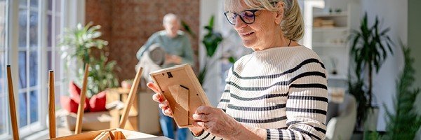 Lady looks at a picture as she packs up a box to move home after porting her Marsden mortgage