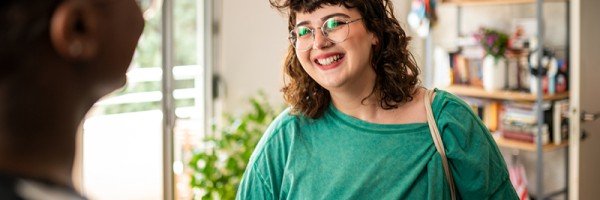 Smiling young woman talks to her friend about the Workplace Savings scheme available through her employer and the Marsden.