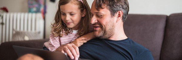 Dad and daughter look at the Marsden's Workplace Savings scheme on their laptop at home.