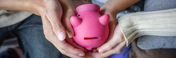 A family holding a piggy bank, taking their first steps towards saving