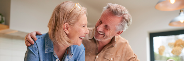 Couple smile in their kitchen after discussing retirement mortgages with the Marsden