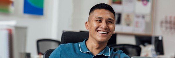 Staff member smiling at his desk