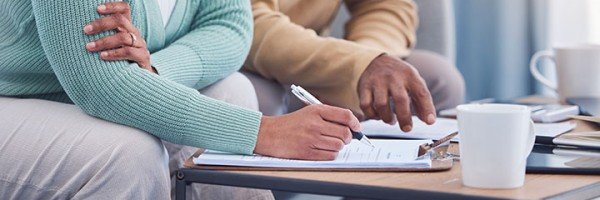 Senior couple sitting to review and sign important documents