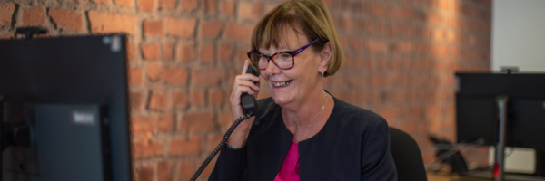 Branch colleague smiles as she speaks to a customer on the phone about their ISA.