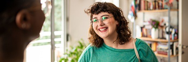 Smiling young woman talks to her friend about the Workplace Savings scheme available through her employer and the Marsden.