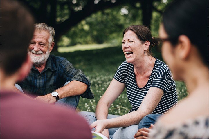 Group of people sit on the grass after volunteering for a local charity