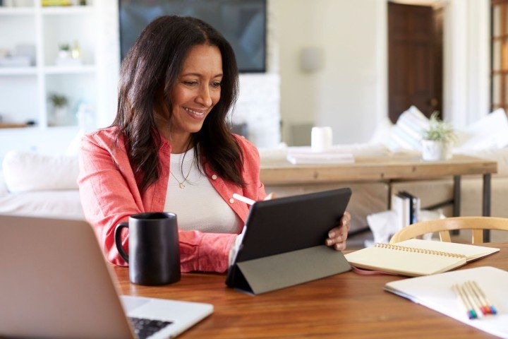 Smiling broker sits in her home after applying for a Marsden Furnished Holiday Let mortgage product on behalf of her client.