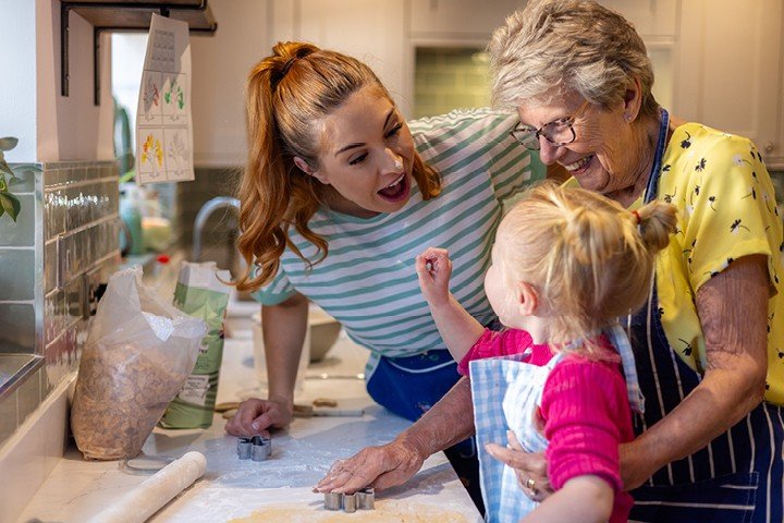 Mother and Grandmother bake in the kitchen with toddler