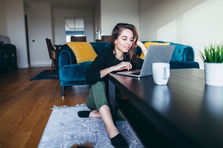 Smiling woman sits in her home after applying for a Marsden First Homes mortgage product.