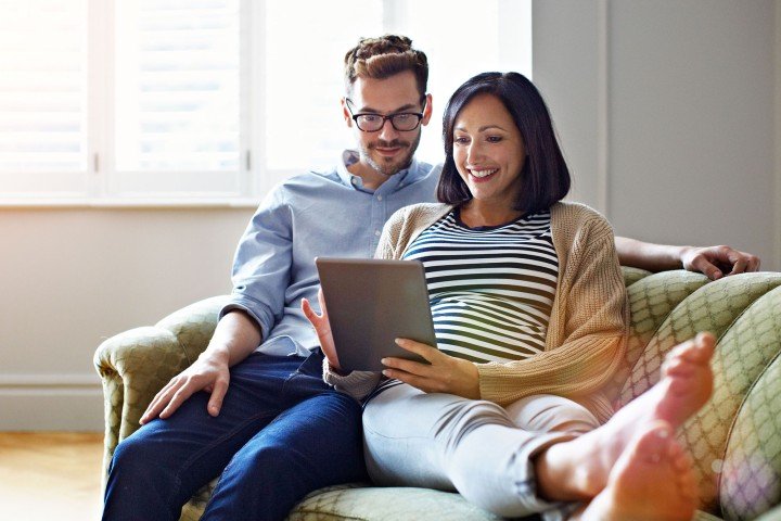 Couple sat together opening a building society account on a tablet