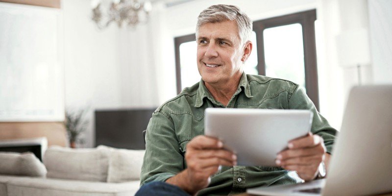 Smiling mature man contacts SPF via email using his tablet.